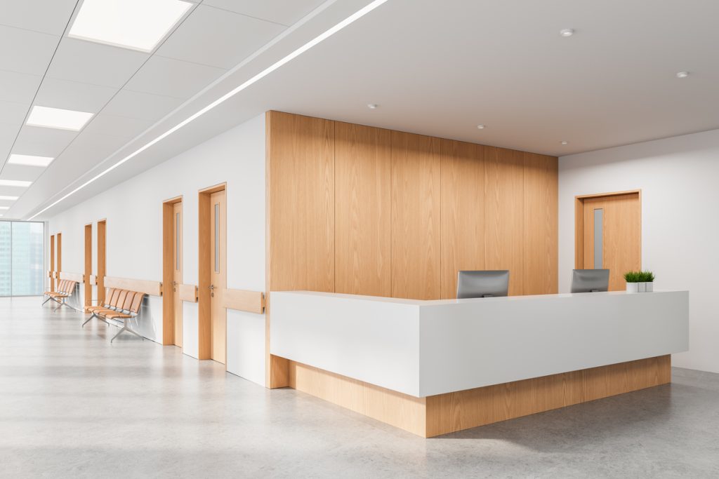 Reception area of a modern medical facility with minimalist wood and white interior design, clean layout, and bright background. 3D Rendering